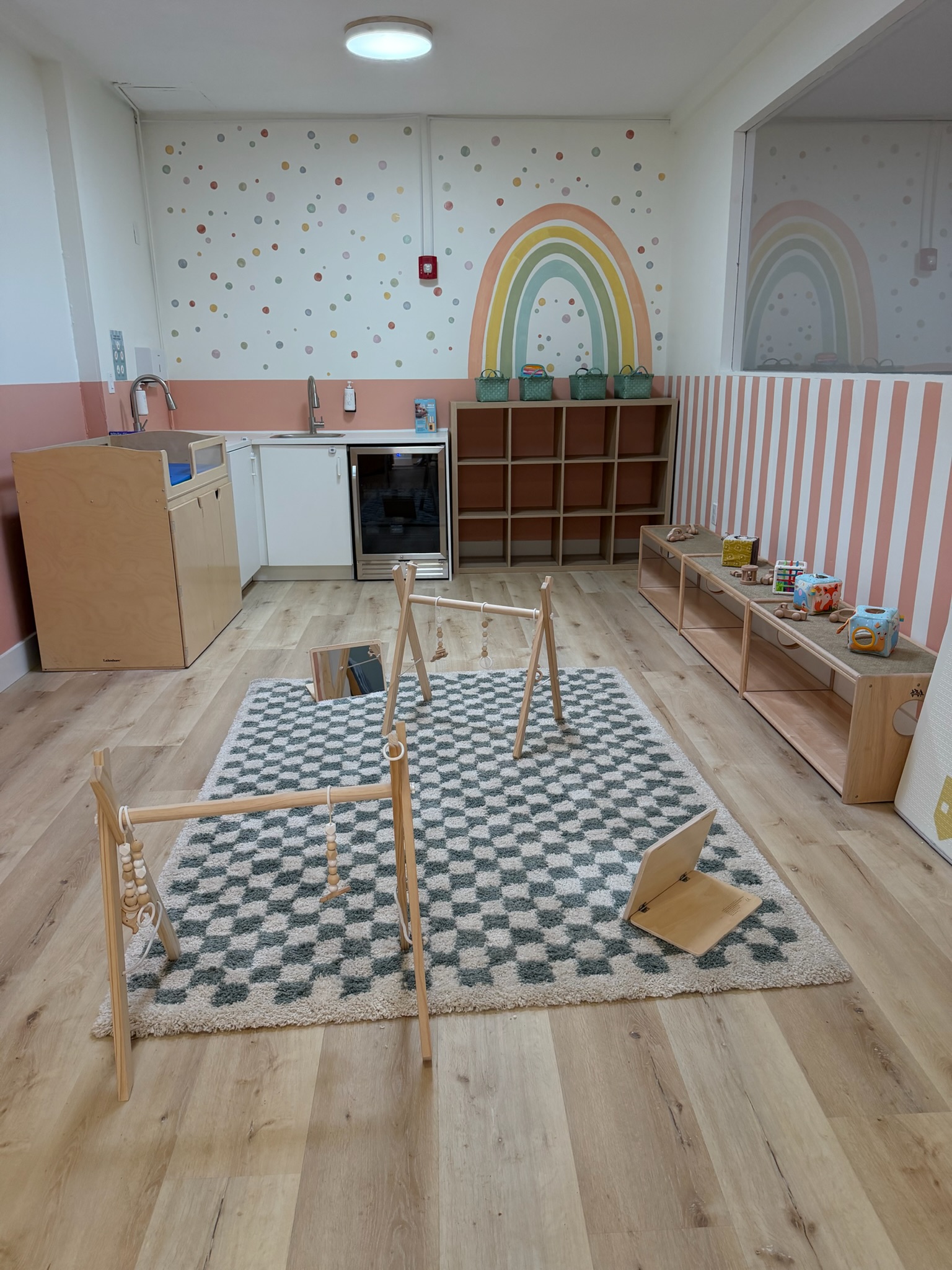 Inside Happy Nook — infant room with rainbow mural