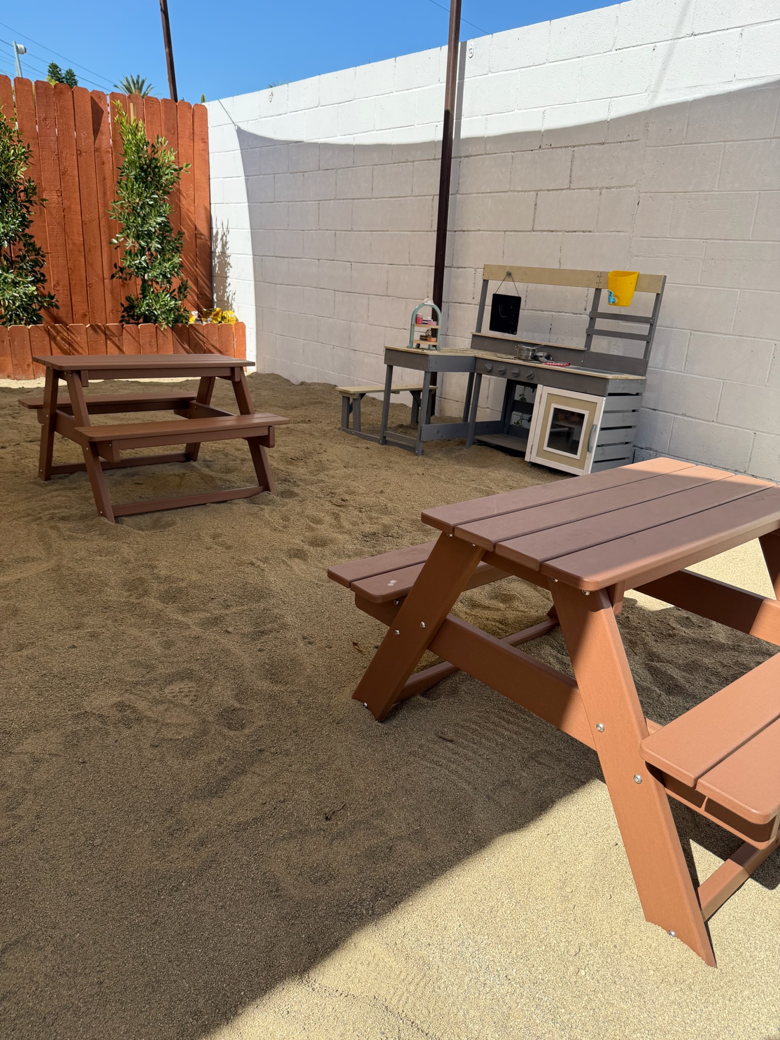 Happy Nook outdoor sand play area with picnic tables and mud kitchen