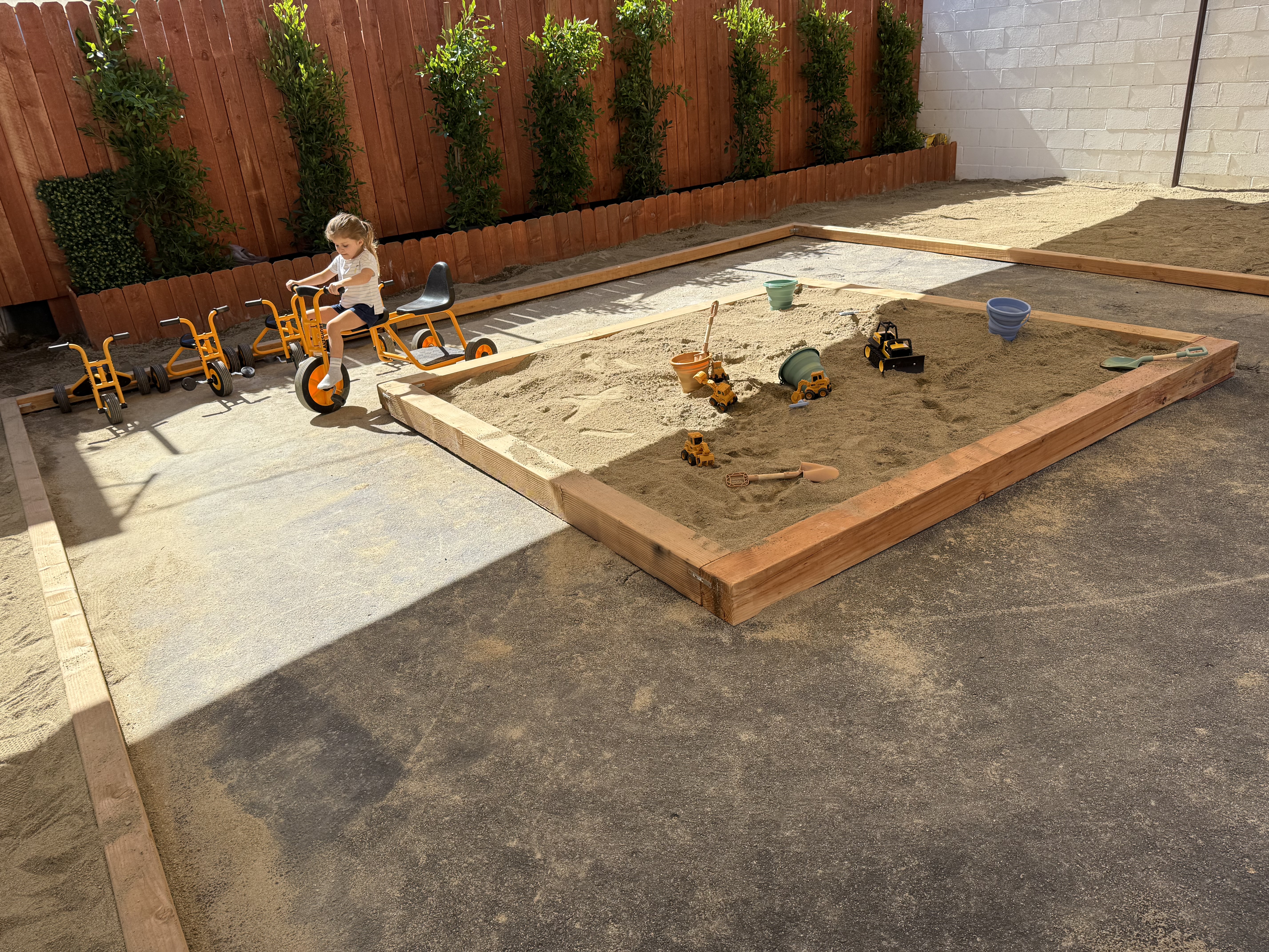 Child playing in the sandbox at Happy Nook outdoor play area