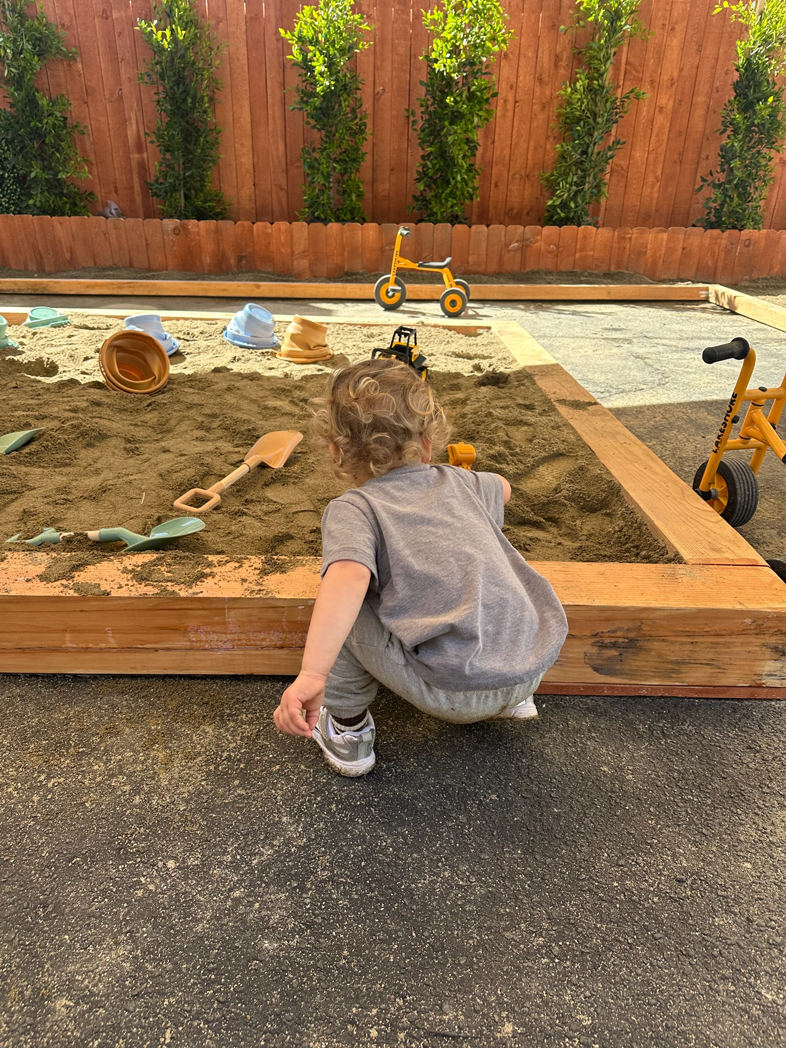 Child playing in the sandbox at Happy Nook outdoor play area