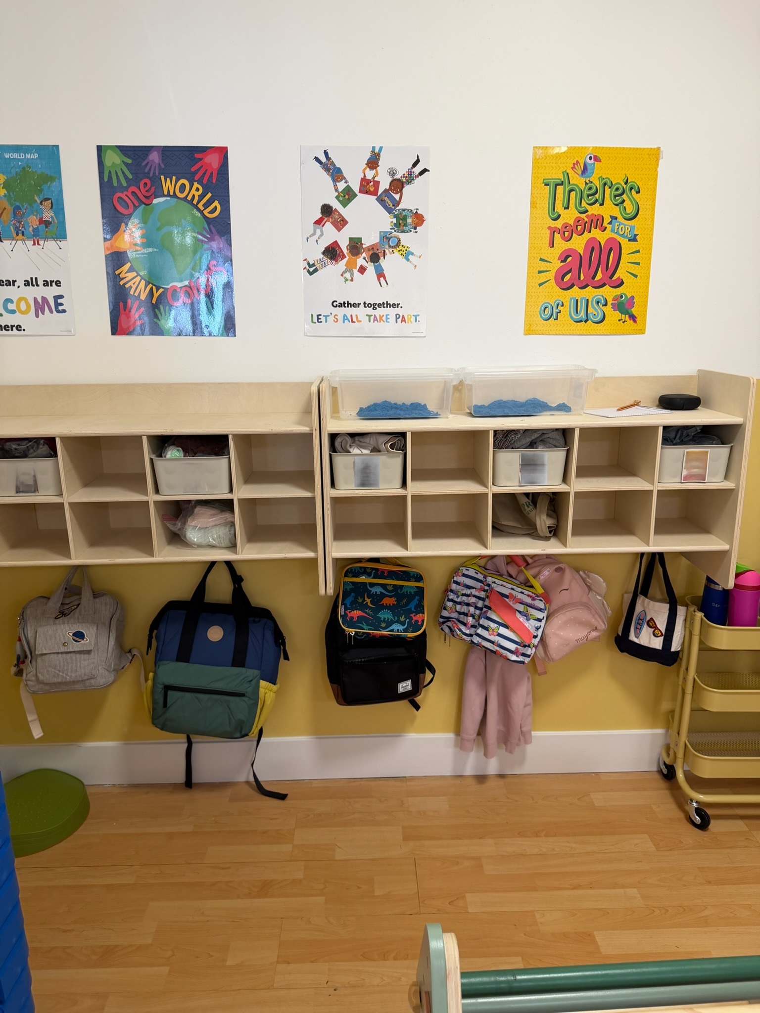 Happy Nook toddler cubby area with backpacks and inclusive classroom posters